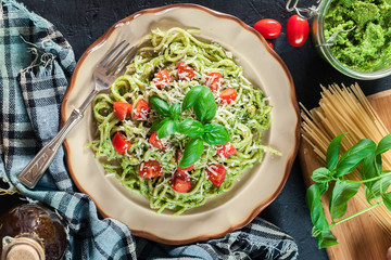 Vegetarian pasta spaghetti with basil pesto and cherry tomatoes
