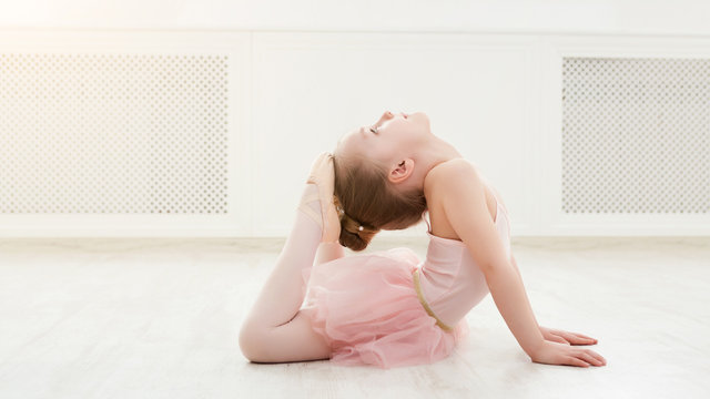 Portrait of little ballerina on floor, copy space