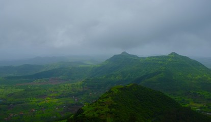 Green landscape surrounded by hills, mountains in monsoon season 