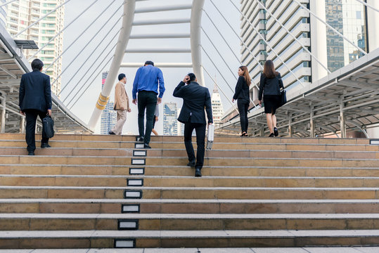 Businessman and Businesswoman up the stairs in rush hour to work. Business people walking up stair in the city.