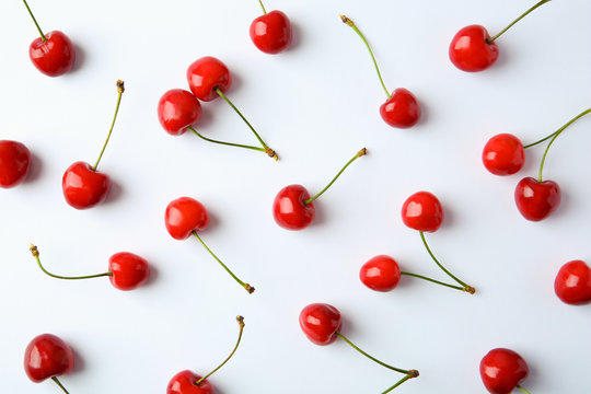 Ripe red cherries on light background, top view