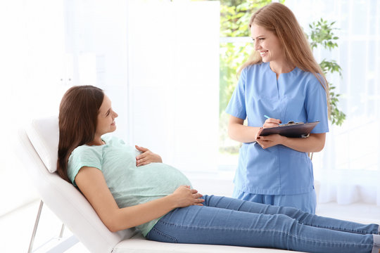 Young pregnant woman with her doctor in clinic