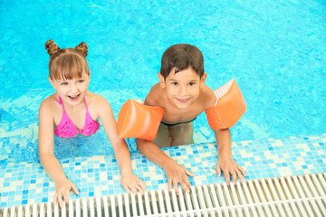 Happy children resting together in swimming pool
