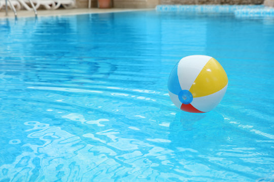 Colorful inflatable ball floating on water in swimming pool