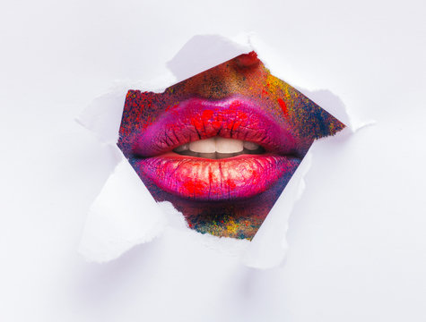 Red lips through torn slot of white paper - Powered by Adobe