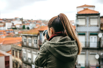 A professional travel photographer or tourist photographs a beautiful cityscape in Porto in Portugal. Professional photography or interesting hobby.