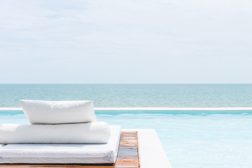 Fototapeta na wymiar White bed at pool seaside the sea with horizon sky