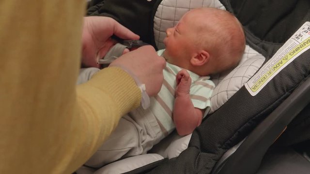 New Born Baby Getting Buckled Into Carseat For The First Time