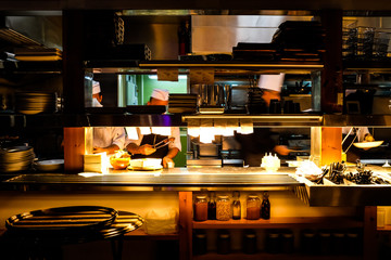 Restaurant kitchen staff working in a balance of light and shadow