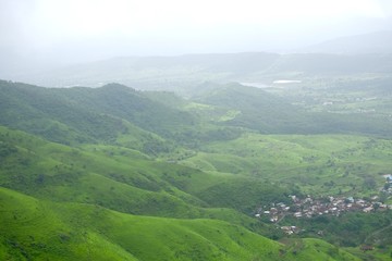 Green landscape surrounded by hills, mountains in monsoon season 