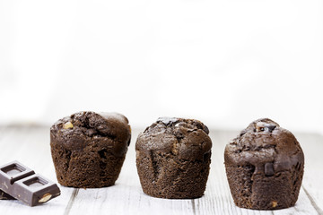 three chocolate cupcakes on table