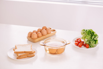 Healthy breakfast consisting of toast, eggs, salad, tomato