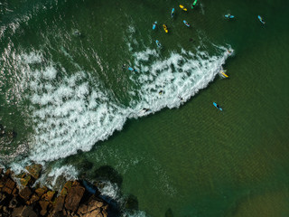 Fototapeta na wymiar Aerial view of surfers in the ocean on a summer day. Surf Spot on the Portuguese coastline. Drone shot.