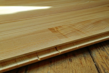 An image of an old wooden floor and a new parquet board.