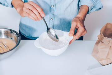 Young woman mixing flour to make dough
