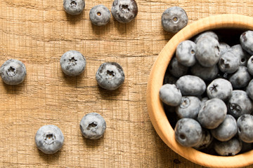 Fresh blueberries in a wooden plate. On an old wooden table. The concept of natural food . Top view. Selective focus