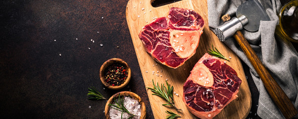 Raw beef steak osso bucco on cutting board.