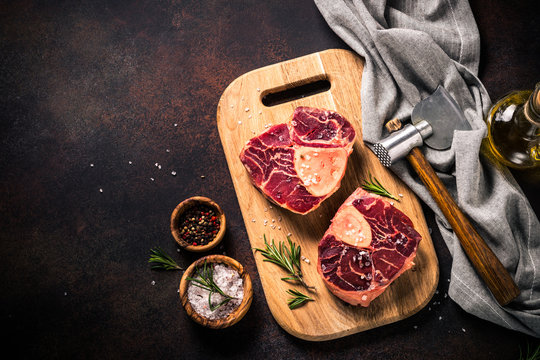 Raw beef steak osso bucco on cutting board.