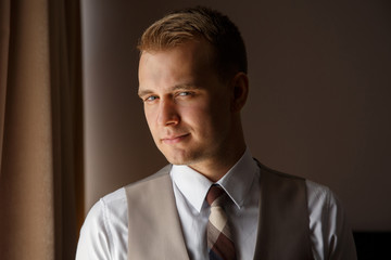 Photo of concentrated man, guy in stylish tuxedo, looking at the camera. Portrait of handsome man, waiting for successful business day