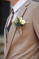 Close-up view of boutonnieres on stylish groom's suit
