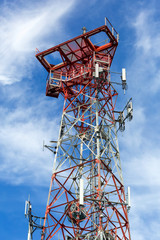 Mobile Phone Cellular Tower against blue sky and white clouds