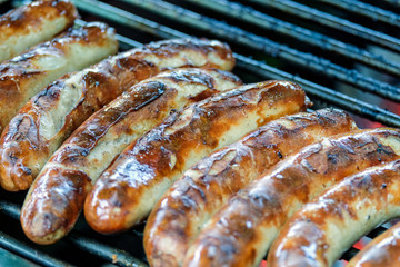 Frische knackige Bratwürste auf dem Grill – Nahaufnahme mit selektivem Fokus und Copyspace