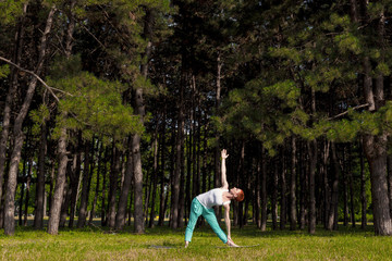 Redhead girl doing Yoga in the park