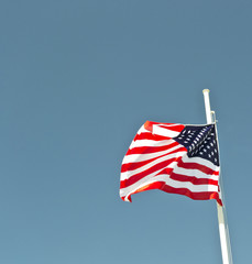 Obraz premium usa flag waving in the wind with blue sky as background