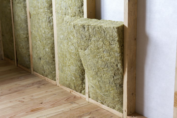 Wooden frame for future walls insulated with rock wool and fiberglass insulation staff for cold...