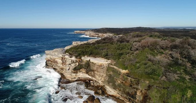 Sandstone cliffs of Cape Solander in Syndye&rsquo;s Kamay Botany bay national park facing Pacific ocean on a sunny day.
