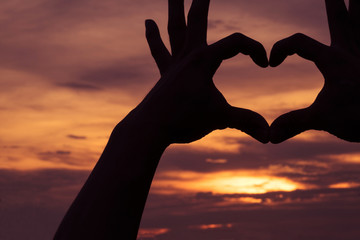 Hands as heart shape with beautiful sky in twilight background,love and romantic concept.