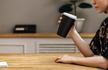 close up hand holding paper cup coffee of take away drinking