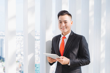 Fototapeta premium Businessman using his tablet in the office