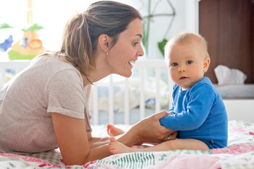 Obraz premium Mother and toddler child in bed, playing together, happiness family concept, kid and mom bonding