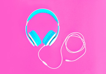 Cool headphones lie on colorful pink background