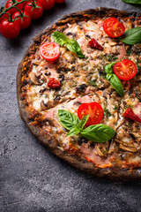 Italian pizza on black dough. Trendy food