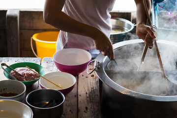 Market woman cooking noodle.
