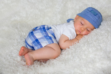 Cute baby boy, sleeping in bed with hat