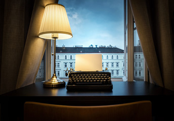 Workplace of a writer, journalist, creator. An old typewriter and a lamp on the table. Retro style....