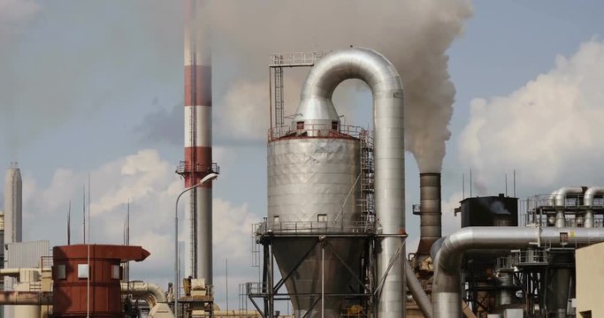 Big industry plant with thick white smoke coming out from chimney