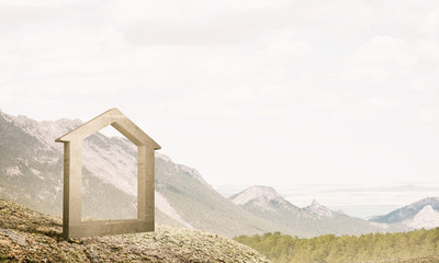 Conceptual image of concrete home sign on hill and natural lands