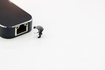 Miniature people: Worker fixing LAN port. Concept of network troubleshoot supporter or maintenance.