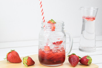 Fresh strawberry syrup and ice cube with soda for summer time on white wooden table background and strawberry fruits with copy space. Special taste of juice.