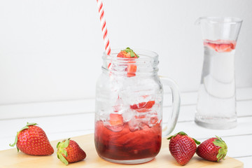 Fresh strawberry syrup and ice cube with soda for summer time on white wooden table background and strawberry fruits with copy space. Special taste of juice.