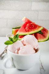 Sweet homemade Watermelon ice cream served with mint, white marble background copy space