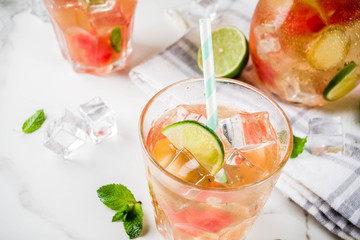 Iced watermelon and lime green tea with mint leaves, marble white background copy space