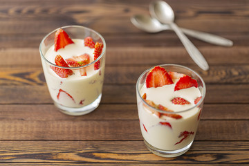 Closed up Yogurt in glass and strawberry on a wooden background. 