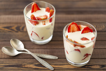 Closed up Yogurt in glass and strawberry on a wooden background. 