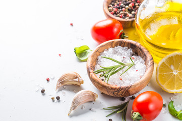 Spices, herbs and olive oil over white stone table. 