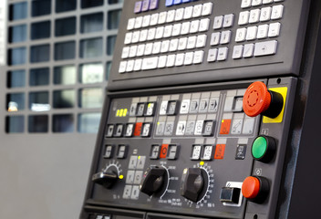 Emergency stop button depth of field, focus blur in CNC machine control panel with machining...